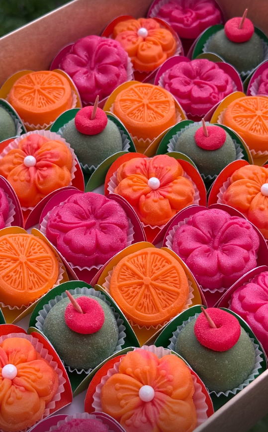 Caja de brigadeiros artesanales en colores vivos con formas de flores y frutas